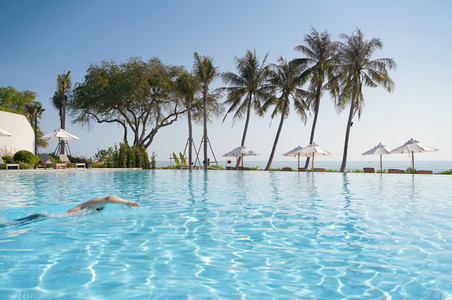 Tourist swimming in the luxury pool resort with seaside view  su