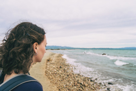girl looking at the sea on a cloudy and sad day