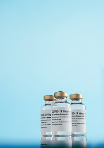 Covid 19 vaccine vials over blue background