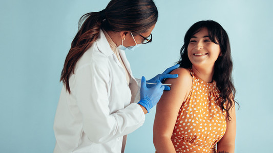 Woman getting flu shot from doctor