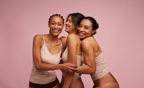 Multi ethnic females in lingerie laughing together