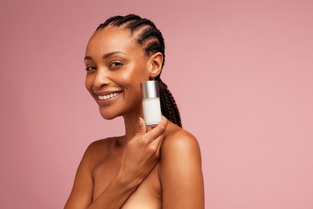 Beautiful female model showing skincare product