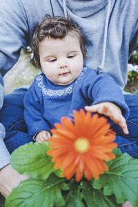 Little baby discovering a huge flower for first time