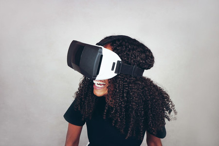 A beautiful young black woman with curly afro hair wears virtual