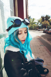 Portrait of a punk or gothic young woman with blue colored hair