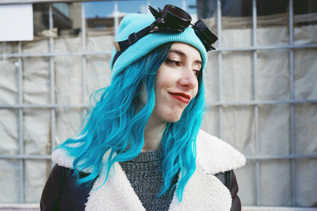 Portrait of a punk or gothic young woman smiles with blue colore