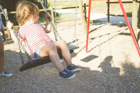 Young girl in a swing at the park