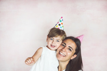 Happy mom and baby girl in a studio photoshoot