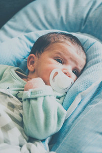 Newborn girl using a pacifier