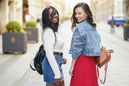 Two female friends having fun together on the street Multiethnic friends