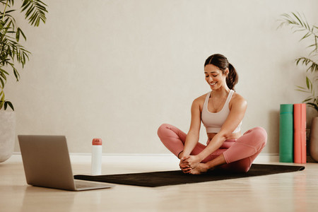 Woman following online workout session at home