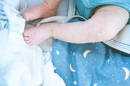 Newborn legs and a sky theme cloth