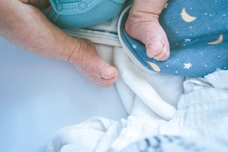 Newborn legs and a sky theme cloth