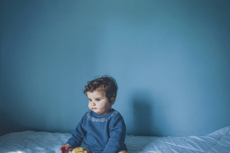 Portrait of a little baby in a blue room