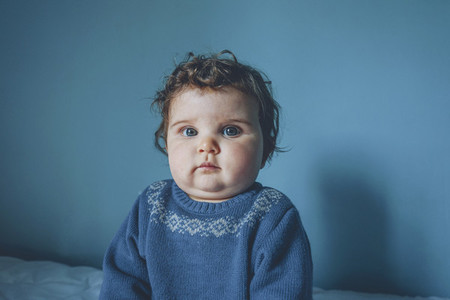 Portrait of a little baby in a blue room