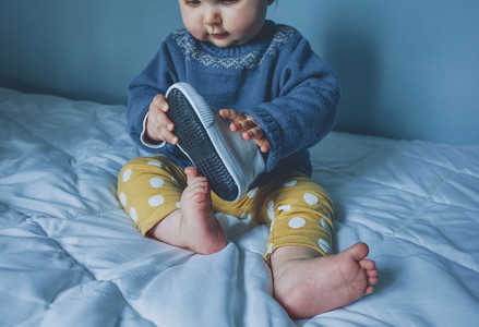Little baby playing with a sneaker