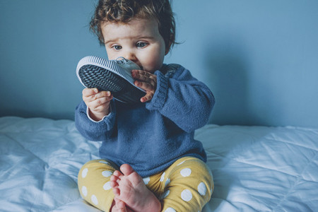 Little baby playing with a sneaker