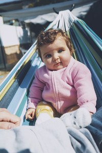 Little baby having fun on a hammock in a sunny day
