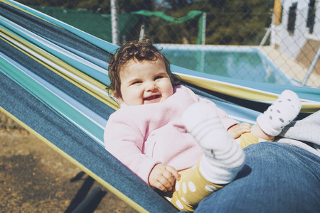 Little baby having fun on a hammock in a sunny day
