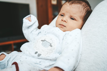 Lovely newborn baby girl with a warm pajama at home