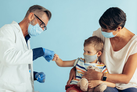 Doctor giving fist bump to a kid in clinic