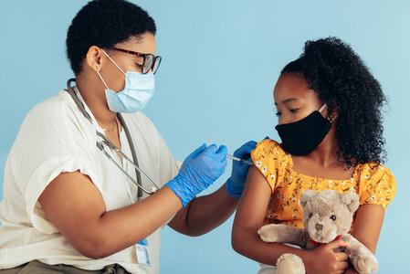 Pediatrician giving vaccine to a girl