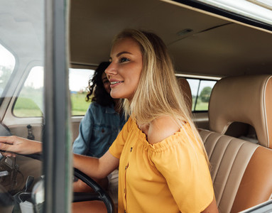 Blond woman driving a car  Two female friends sitting in a van during summer vacation