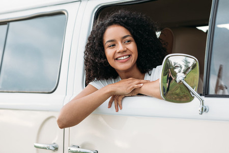 Young mixed race woman looking out of the car and smiling