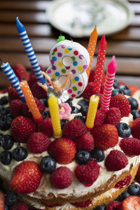 Vibrant candles and number 8 candle on fruit birthday cake
