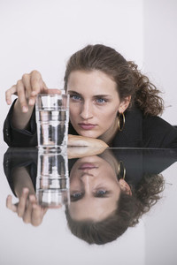Businesswoman looking at water glass on conference table