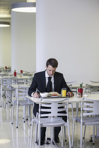 Businessman looking down at lunch tray in office cafeteria