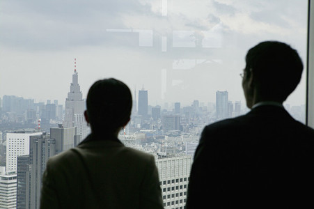Business people looking at cityscape from highrise office window