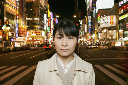 Portrait serious businesswoman on city street at night Tokyo Japan