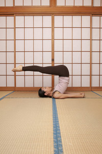 Young woman practicing yoga pose on mat