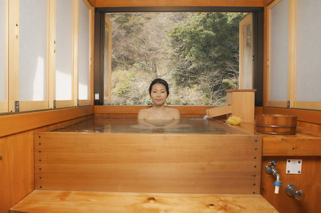 Portrait beautiful young woman soaking in pool at Japanese Onsen