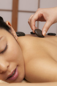 Close up young woman receiving hot stone massage