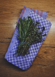Fresh rosemary and thyme herb bunch on kitchen towel