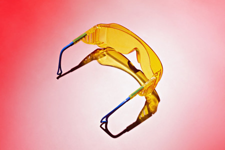 Yellow safety goggles on red background