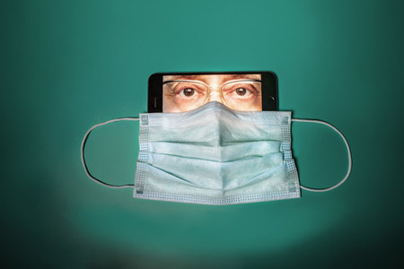 Face mask covering face of man on smart phone screen