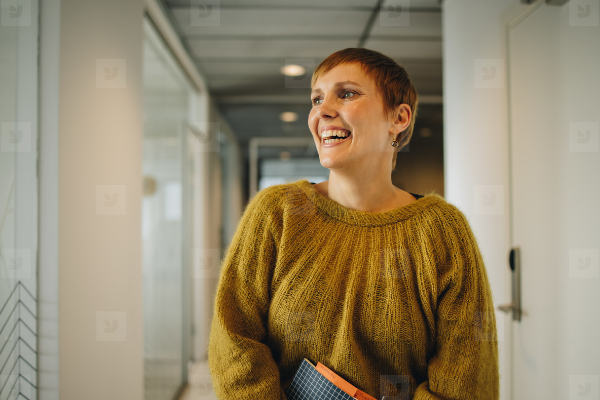 Female executive standing in office corridor