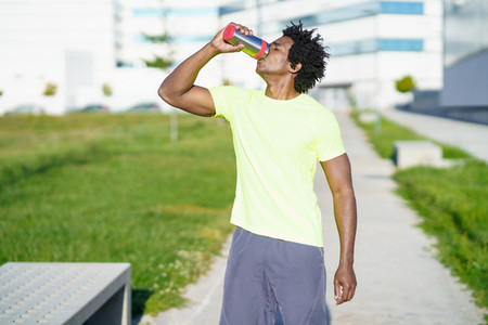 Black man drinking during exercise Runner taking a hydration break