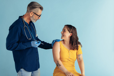 General practitioner giving vaccine to woman