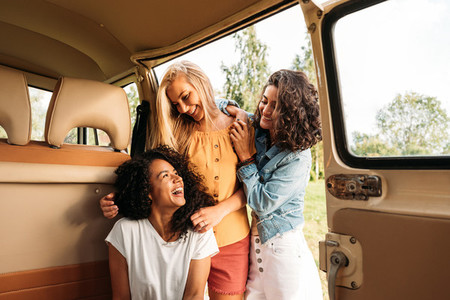 Three cheerful women having fun during road trip
