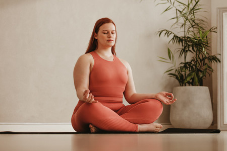 Woman meditating in fitness studio