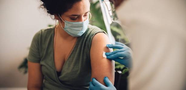Woman receiving covid vaccine at home