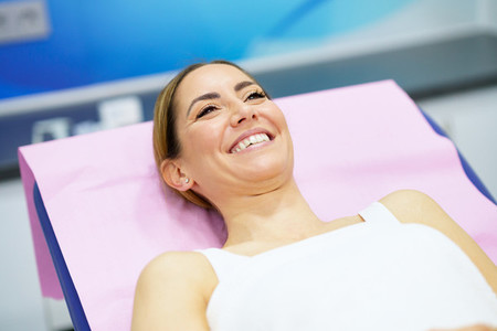 Middle aged woman lying on the stretcher in an aesthetic clinic