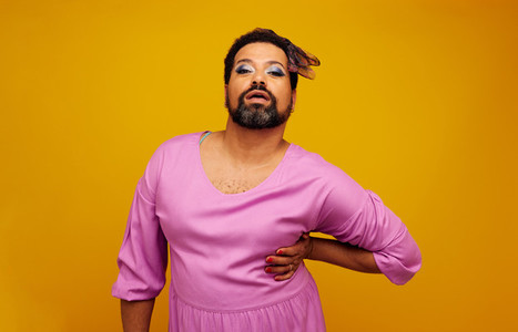 Drag queen posing on yellow background