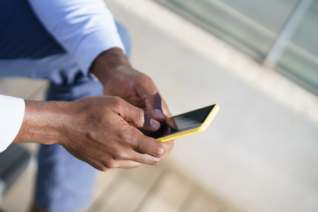 Hands of unrecognizable black man using a smartphone