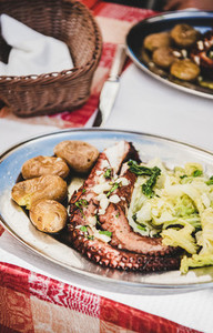 Traditional portuguese grilled octopus  boiled potato and cabbage on plate
