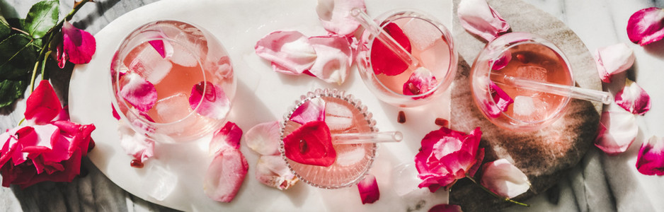Rose lemonade with ice and pink rose petals  wide composition
